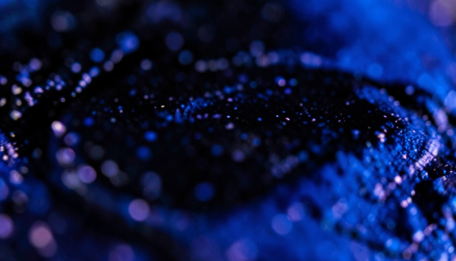 Macro shot of glossy dark ink texture with subtle purple undertones and a moody artistic feel
