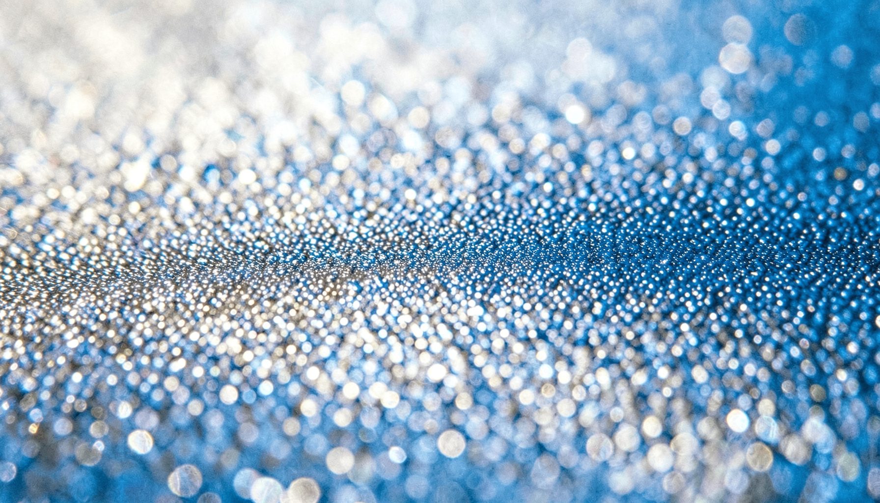 Extreme close-up of glossy film grain texture in soft silver and grey tones with a nostalgic mood